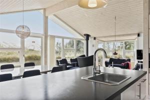 a kitchen with a sink and chairs and windows at 0049-Romo-Magevej-5 in Høm +18 photos