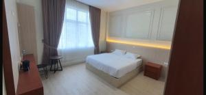 a hotel room with a bed and a window at Mabit Hotel Syariah in Takengon