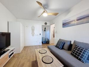 a living room with a couch and a flat screen tv at Cocon Cosy in Carnon-Plage