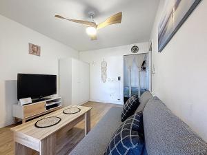a living room with a couch and a flat screen tv at Cocon Cosy in Carnon-Plage +7 photos