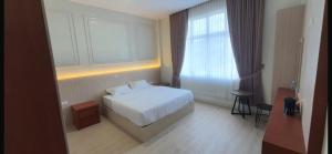 a hotel room with a bed and a window at Mabit Hotel Syariah in Takengon