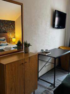 a room with a mirror and a table and a bed at Apple Economy Hotel in Kaunas