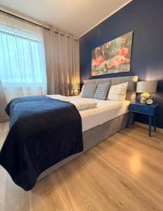 a bedroom with a large bed and a large window at Modern 2-Room Apartment with Large Balcony & Private Parking in Gdańsk