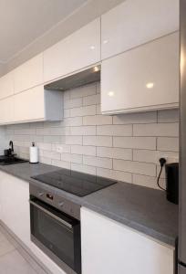 a kitchen with white walls and a stove top oven at Modern 2-Room Apartment with Large Balcony & Private Parking in Gdańsk +14 photos