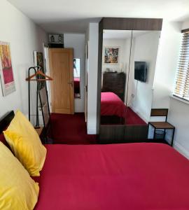 a bedroom with a red bed and a mirror at Superb Guest Room in London