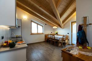 a kitchen and a dining room with a table at Agritur Rizzi di Inama Ugo in Coredo