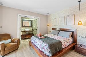 a bedroom with a bed and a chair and a mirror at Ca Marga in Santa Pola +36 photos