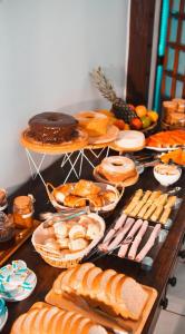 a table topped with lots of different types of bread at Jeromia Casa e Pousada in Rifaina +20 photos