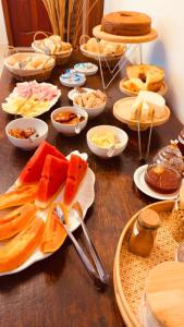 a wooden table with plates of food on it at Jeromia Casa e Pousada in Rifaina
