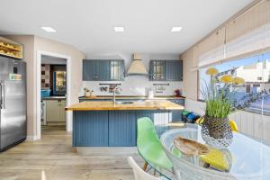 a kitchen with blue cabinets and a glass table at Ca Marga in Santa Pola