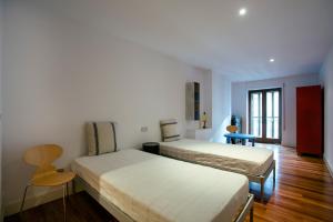sypialnia z dwoma łóżkami, stołem i krzesłami w obiekcie Alderdi Eder by People Rentals w mieście San Sebastián