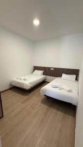 two beds in a room with wooden floors at Céntrico apartamento en Valdemoro in Valdemoro +11 photos