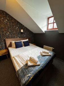 a bedroom with a bed with two towels on it at Apple Economy Hotel in Kaunas