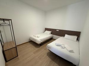 a small room with two beds and a mirror at Céntrico apartamento en Valdemoro in Valdemoro
