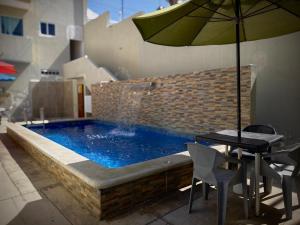 a swimming pool with a table and an umbrella at Royal Pacífico Manzanillo in Manzanillo +20 photos