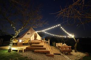 a white tent with lights on it at night at Osada na hůrce in Hustopeče +23 photos