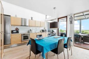 a kitchen and dining room with a blue table and chairs at 0343-Romo-Vestergade-329 in Høm