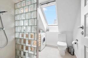 a bathroom with a toilet and a window at 0343-Romo-Vestergade-329 in Høm +15 photos