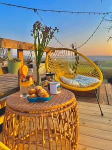 a rattan table and chair on a deck with food on it at Osada na hůrce in Hustopeče