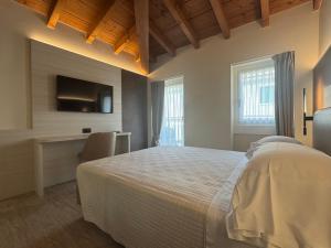 a bedroom with a bed and a desk and a tv at Hotel Roma in Garda +41 photos