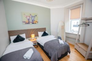 a bedroom with two beds and a mirror and a window at Limefield Residence in West Calder