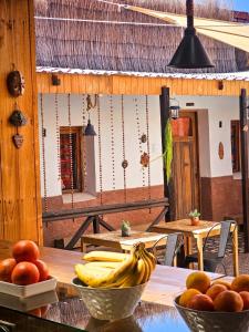 a wooden table with bowls of bananas and oranges on it at Vientos - La Yareta in San Pedro de Atacama