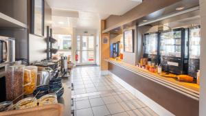 a restaurant kitchen with a counter with food on it at Kyriad ECO - Lorient Lanester in Lanester