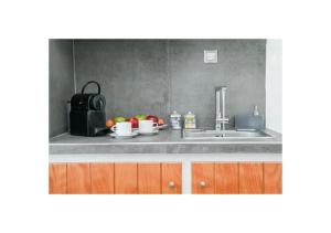 a kitchen counter with a sink and fruits on it at Kafieris Blue in Firostefani +33 photos
