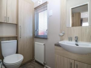 a bathroom with a white toilet and a sink at Pheasant Lodge in Holyhead +17 photos