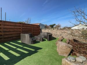 a garden with benches on the grass at Pheasant Lodge in Holyhead