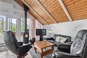 a living room with leather furniture and a tv at 0152-Romo-Ejnar-Mikkelsensvej-5 in Høm
