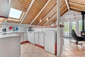 a kitchen with white cabinets and a chair in it at 0152-Romo-Ejnar-Mikkelsensvej-5 in Høm +13 photos