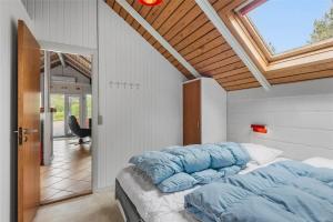 a bedroom with a bed with blue pillows on it at 0152-Romo-Ejnar-Mikkelsensvej-5 in Høm