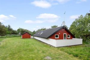 a red and white building in a field at 0152-Romo-Ejnar-Mikkelsensvej-5 in Høm