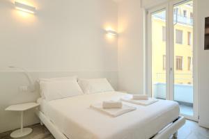 a white bedroom with a large white bed and a window at Italianflat - Vandom 2 Duomo Luxury Rooms Foresteria Lombarda in Milan