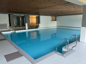 a large swimming pool with blue water at Ferienwohnung Naturgenuss in Oy-Mittelberg