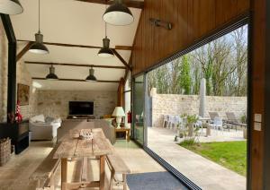 a living room with a wooden table and a large window at Clos de La Brelaisière in Chauvigny