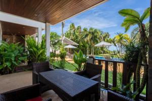 an outdoor patio with a table and chairs and a pool at Beachfront! 2 Bedroom Apartment A4 - 110 Sqm in Ko Bu Bu