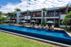 a hotel with a swimming pool with chairs and umbrellas at Beachfront! 2 Bedroom Apartment A4 - 110 Sqm in Ko Bu Bu