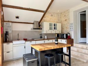 a kitchen with white cabinets and a counter with stools at Clos de La Brelaisière in Chauvigny