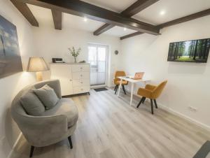 a living room with a chair and a table with a laptop at Hof Steinhütten in Westerhever