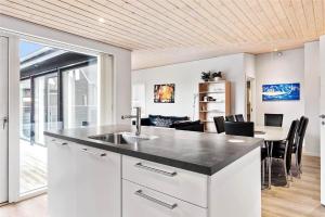 a kitchen with a sink and a table with chairs at 0342-Romo-Vestergade-355 in Høm