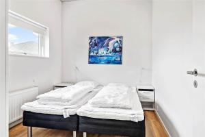 a white room with a bed and a painting on the wall at 0342-Romo-Vestergade-355 in Høm