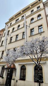 a building with a tree in front of it at FLEUR DE LIS HOTEL in Prague