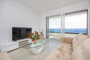 a living room with a couch and a tv at Sunset Apartments in Makarska