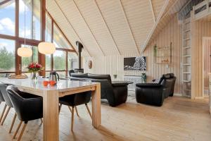 a living room with a table and leather chairs at 0212-Romo-Lejrbjergvej-24 in Høm