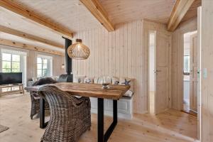a dining room with a wooden table and chairs at 0145-Romo-Hattesvej-36 in Høm +13 photos