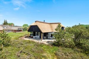 a house with a thatched roof on top of a field at 0145-Romo-Hattesvej-36 in Høm