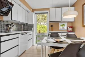 a kitchen with white cabinets and a table and chairs at 0442-Romo-Vestergade-137-Ap-101 in Høm
