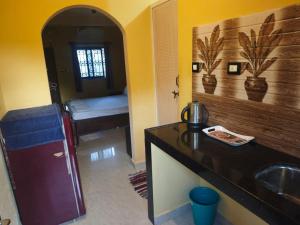a bathroom with a sink and a room with a bed at Carvalhos Regina 100 mtrs Patnem beach in Canacona